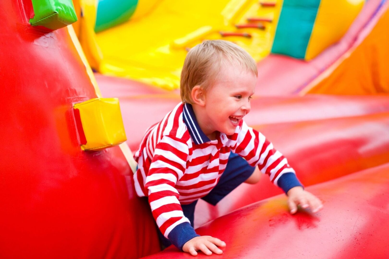 A little boy that is sitting on some kind of slide