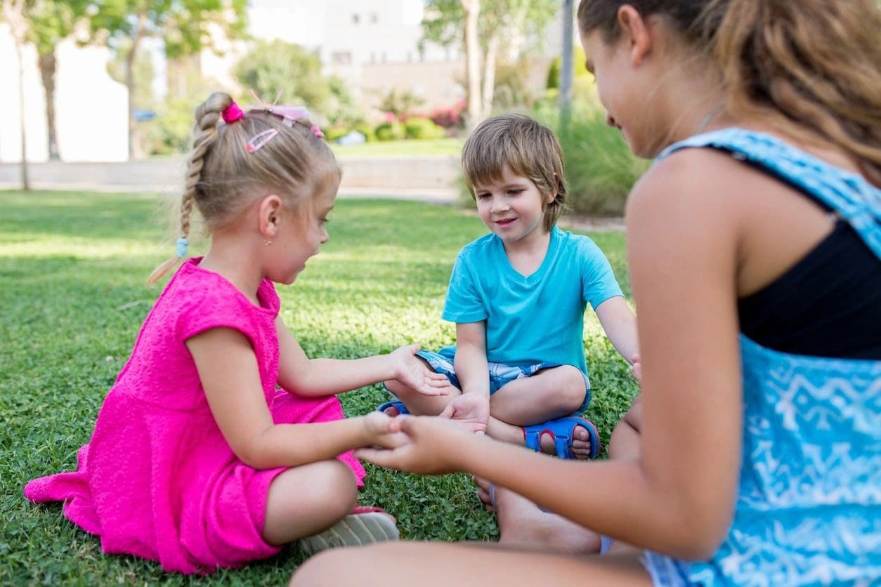 A group of children sitting on the grass.